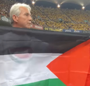 أعضاء الحملة في رومانيا يرفعون علم فلسطين أثناء مباراة رومانيا ودولة الاحتلال
